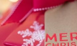 Christmas presents in red wrapping paper with snowflakes and a tag saying Merry Christmas