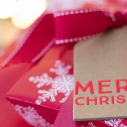 Christmas presents in red wrapping paper with snowflakes and a tag saying Merry Christmas